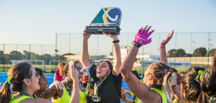 Goleira e capitã Caroline Marson levanta o troféu de tri campeã para o Macau.