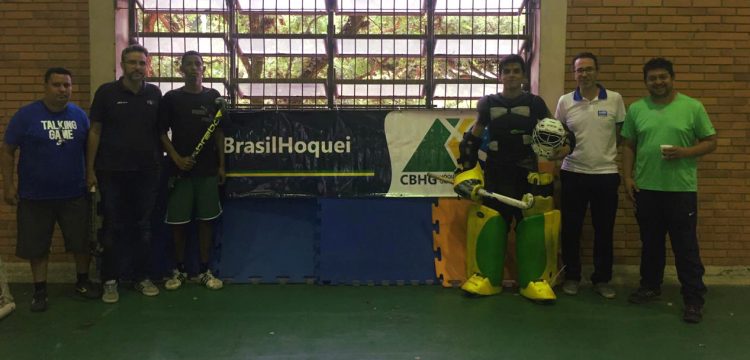 Alunos e professores do workshop de arbitragem posam ao lado do banner da Confederação.